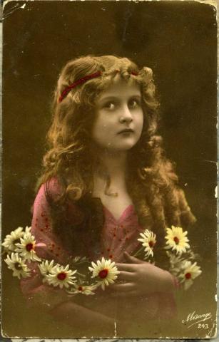 Postcard from Judy to Annie. Front depicts a portrait of a woman with flowers in her hair.