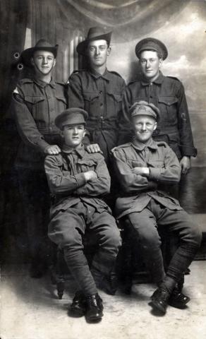 Black and white portrait of five men in uniform.