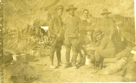 Sepia faded photograph of soldiers in uniform outdoors.