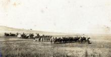 Sepia photograph of horses on parade.